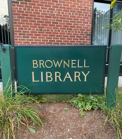 A green sign that of Brownell Library on in Essex Junction