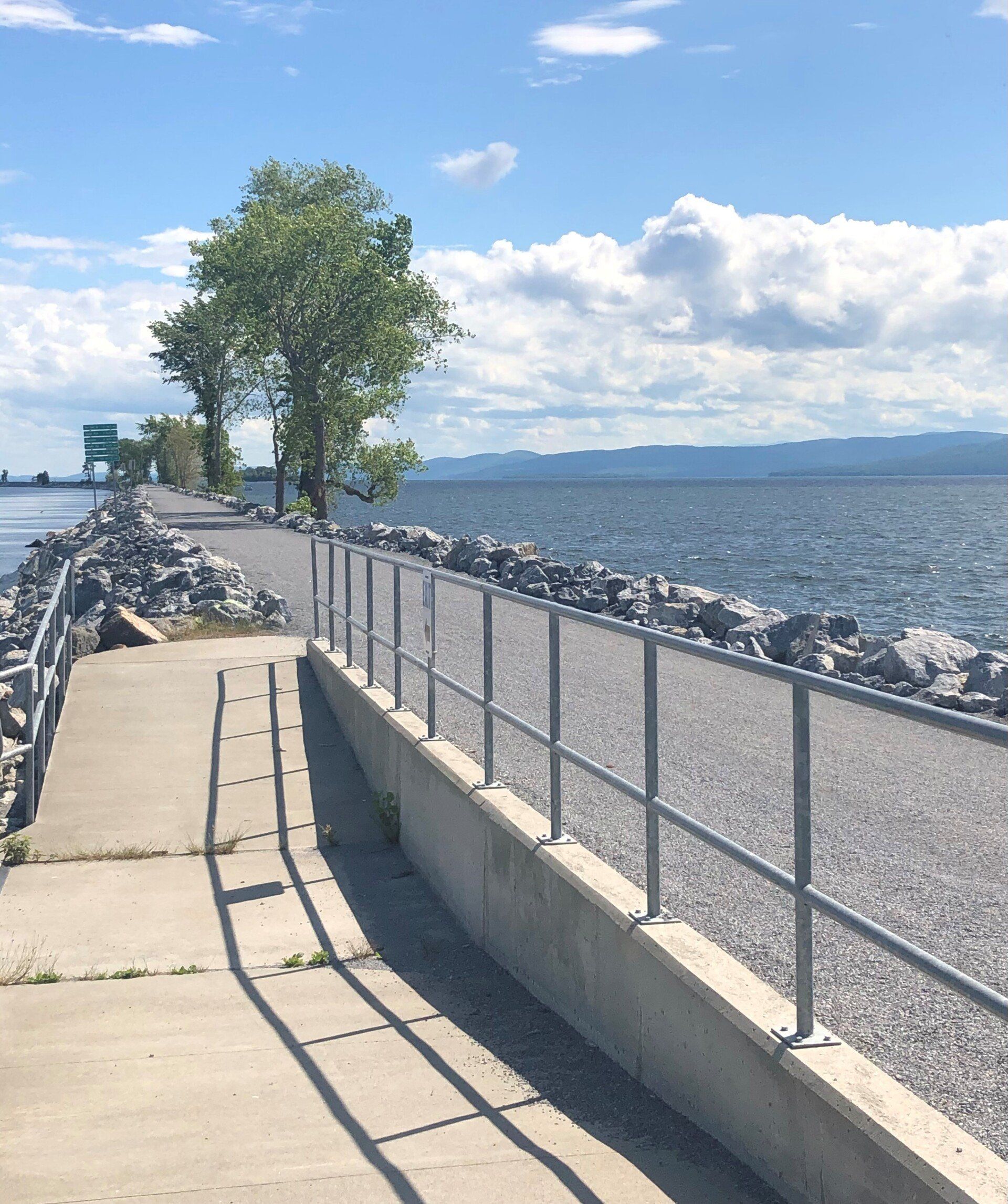 A concrete walkway along the shore of a body of water