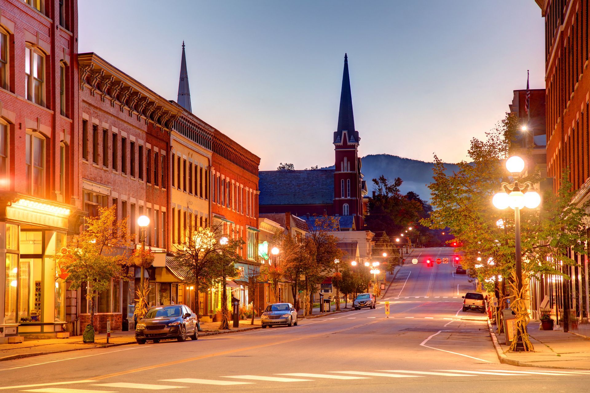 A city street at night with a church in the background.