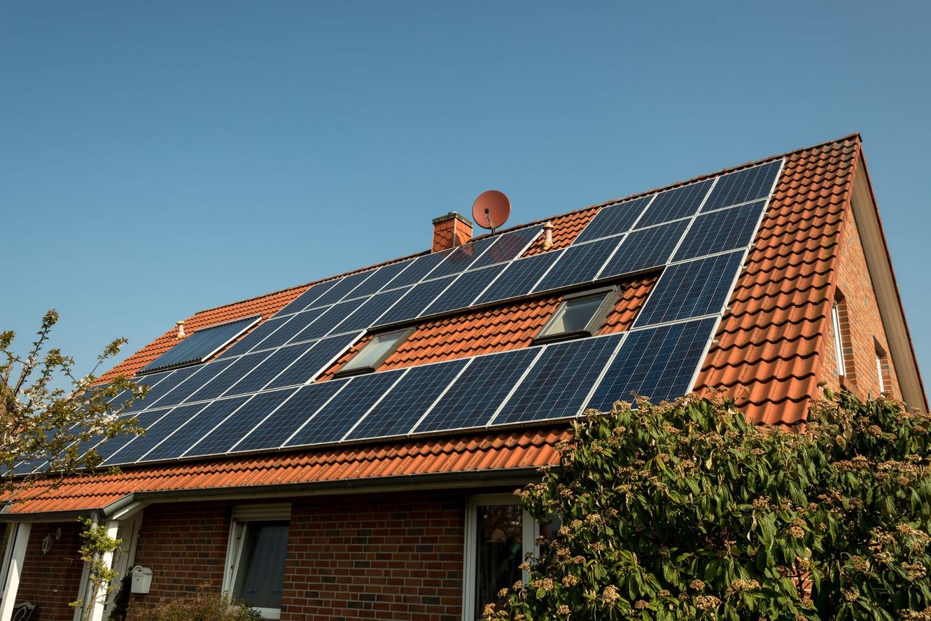 House roof with solar panels under a clear blue sky