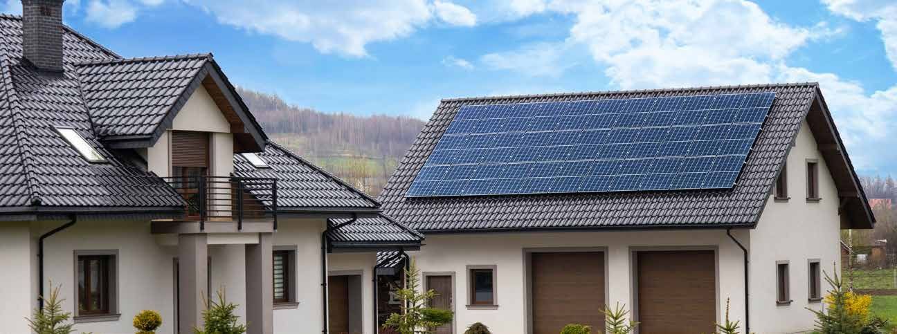 White house rooftops with solar panels under a blue sky