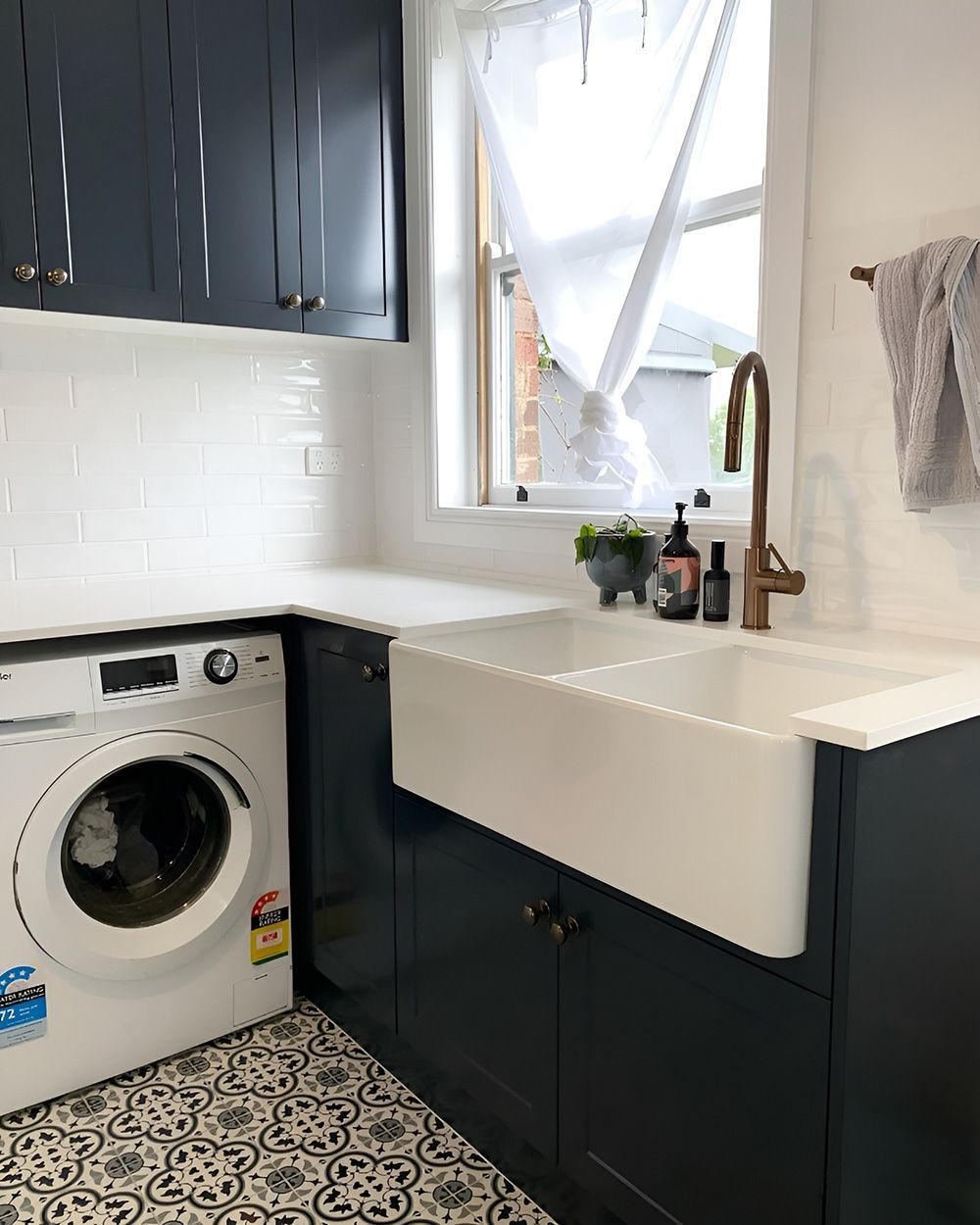 Kitchen and Laundry Room with Navy Cabinets, White Sink, and Washing Machine