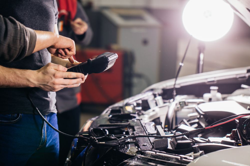 A Man is Working on a Car in a Garage — Noosa Batteries in Noosaville, QLD