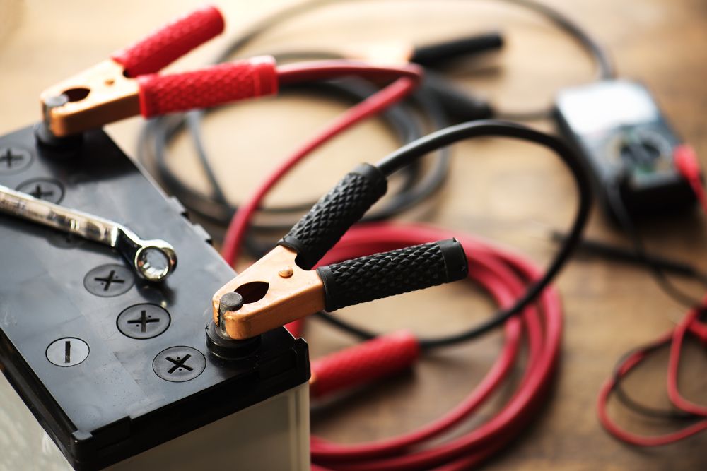 A Close Up of a Battery With Jumper Cables Attached to It — Noosa Batteries in Noosaville, QLD