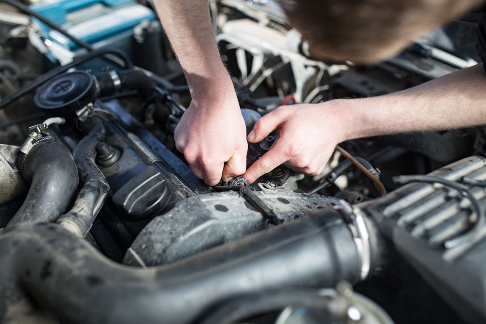 A Man is Working on the Engine of a Car — Noosa Batteries in Nambour, QLD