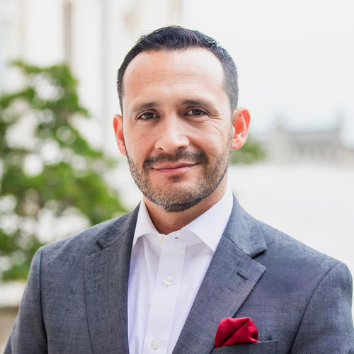 Portrait of a man in a gray suit with a red pocket square outdoors