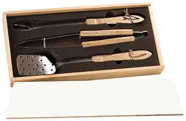 Stainless steel grilling tools in a wooden box, including tongs and spatulas.