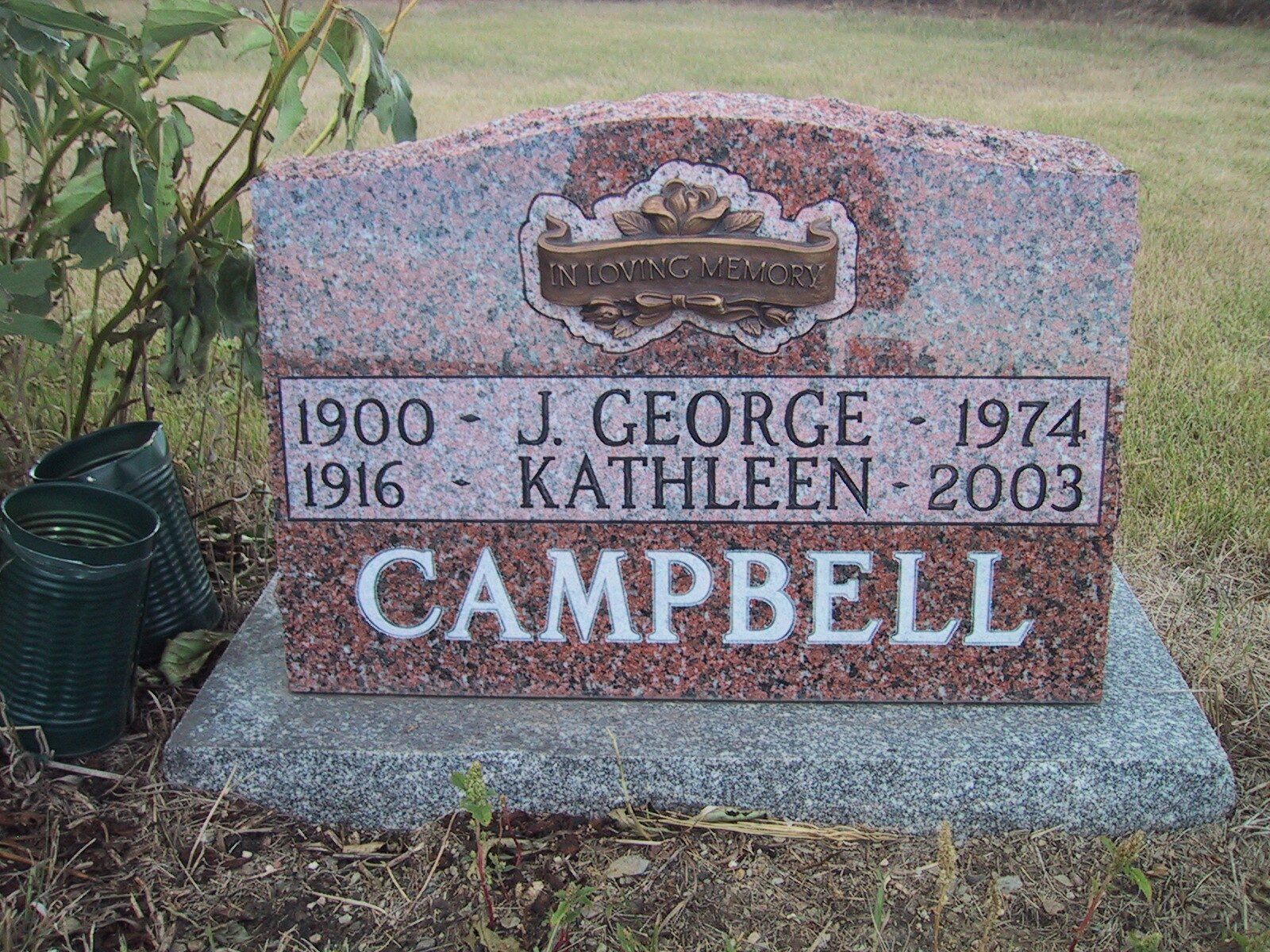 CAMPBELL gravestone with J. George and Kathleen dates, set in a grassy cemetery.