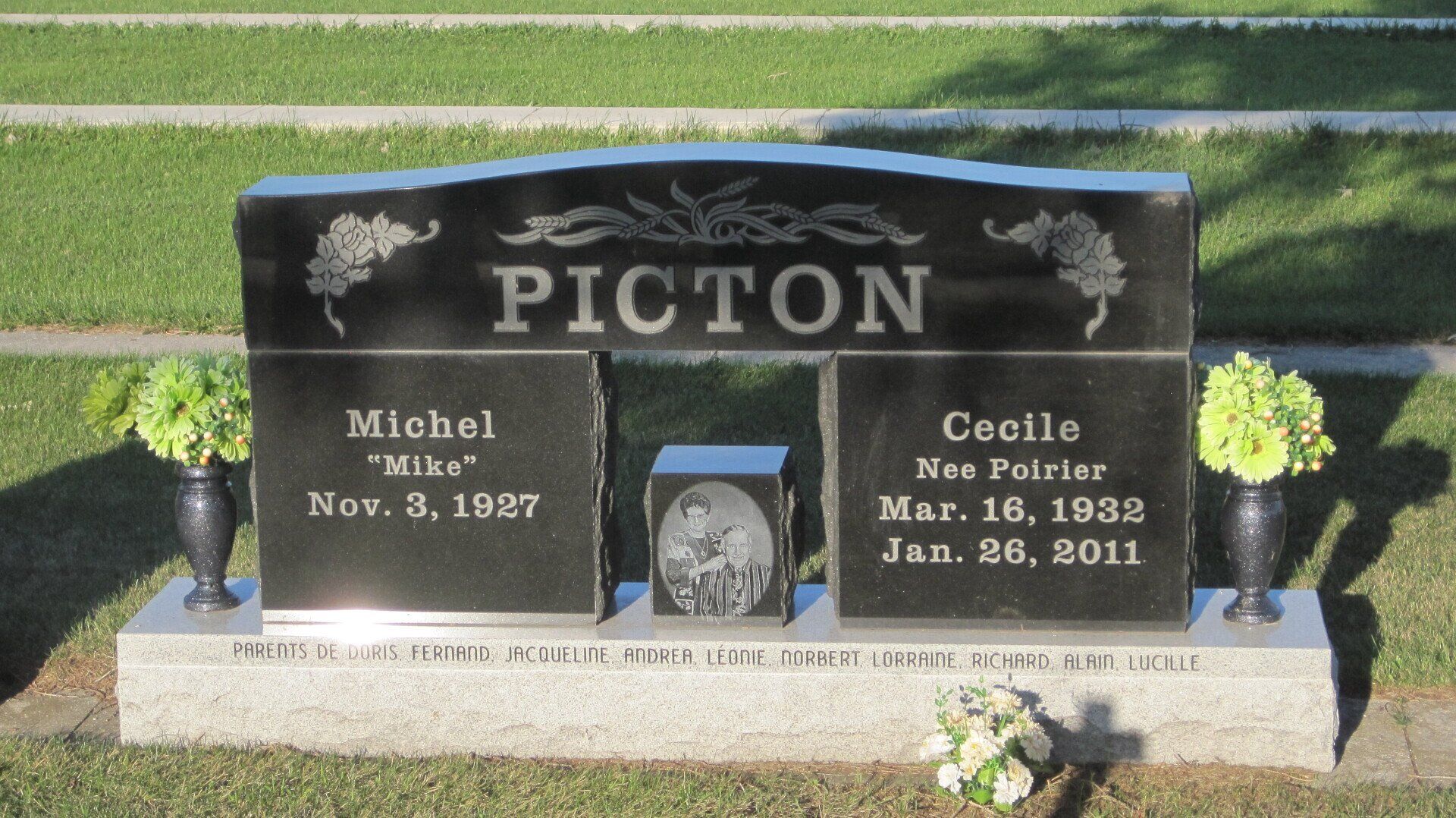 Black granite Picton cemetery headstone with engraved names and small central photo plaque.