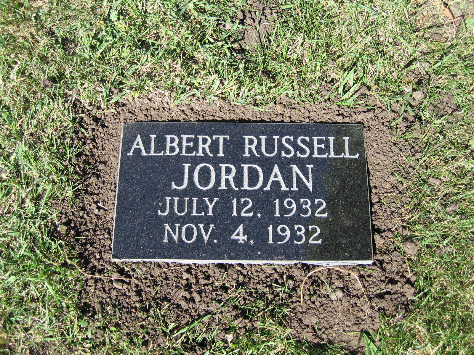 Gravestone for Albert Russell Jordan with dates July 12, 1932 and Nov. 4, 1932 in grass