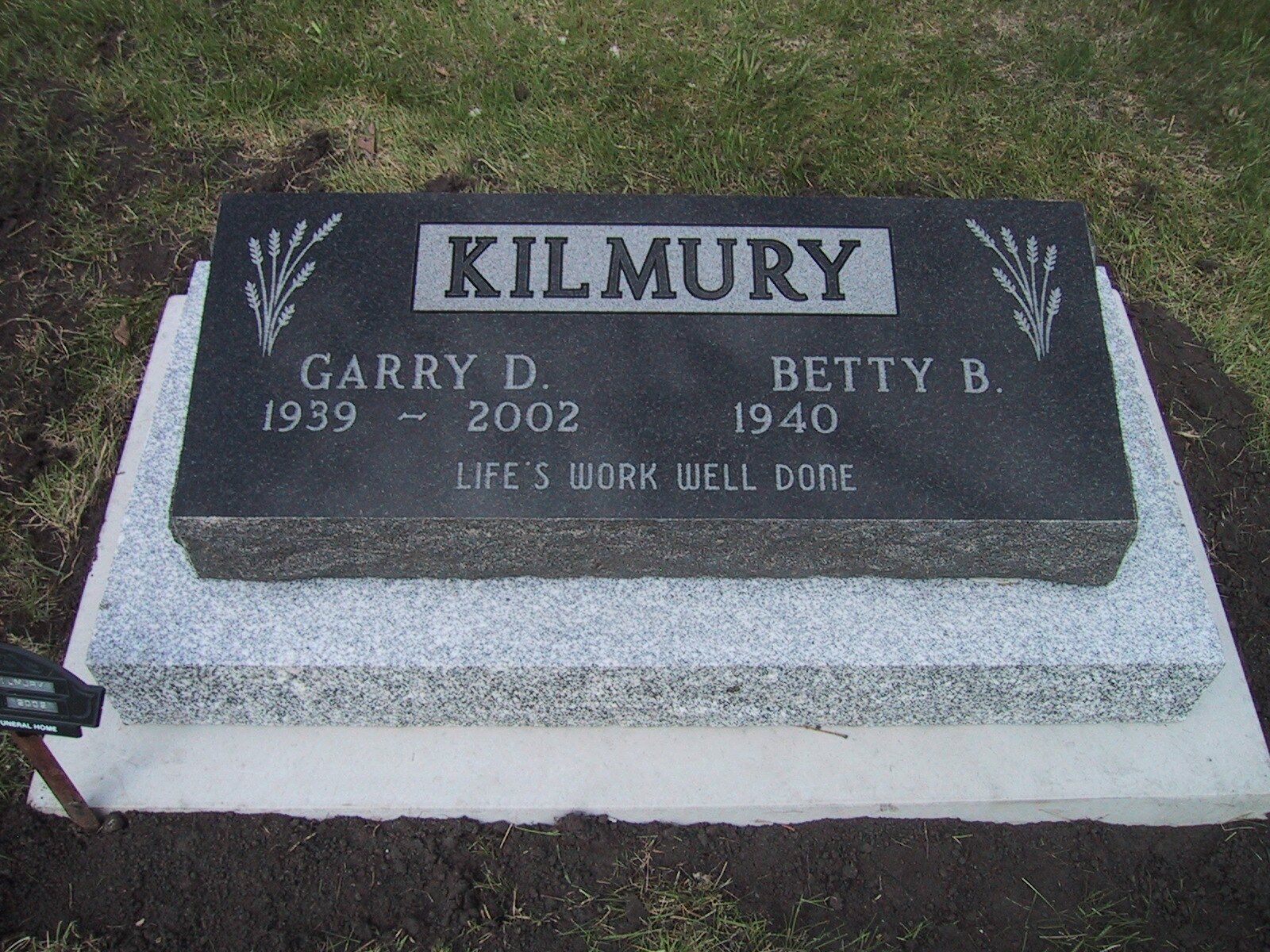 Kilmury gravestone for Garry D. and Betty B., with a military emblem on a gray marker.