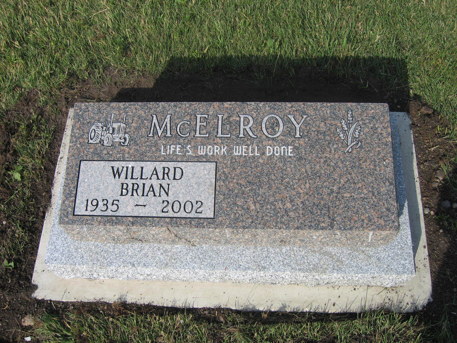 Gravestone for William Brian McElroy, 1935–2002, set in grass.