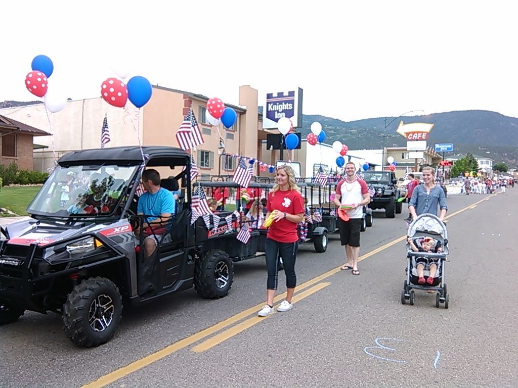 A group of people are walking down a street in a parade.