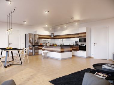 Modern open-plan kitchen and living room with white cabinets, wood floors, and black sofa