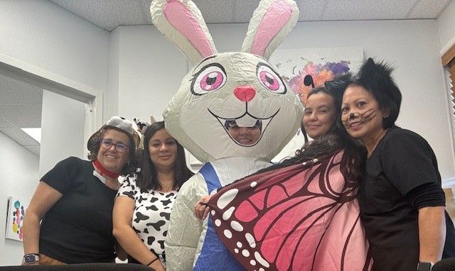 A group of women are posing for a picture with a bunny mascot.