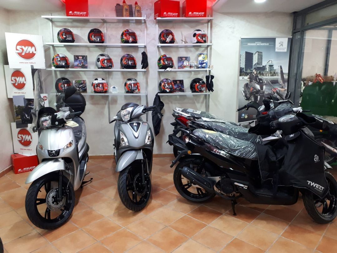 Three scooters are parked in a showroom.