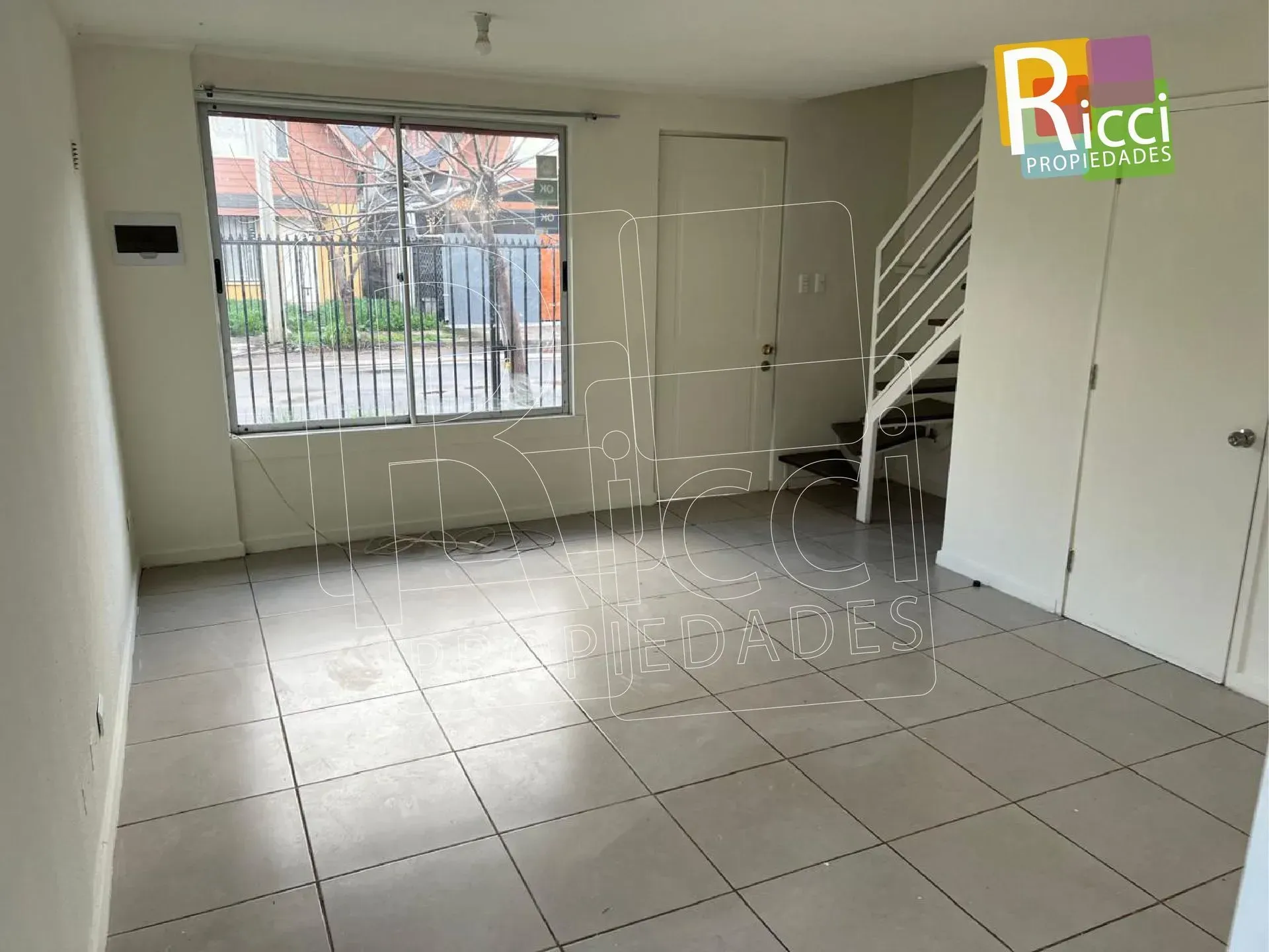Dos casas de madera marrón con patios delanteros cerrados con verjas, en una tranquila calle residencial.