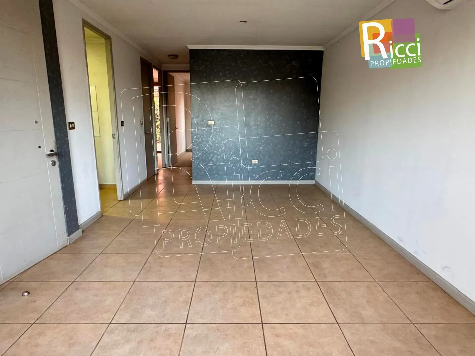 Casa de una sola planta con portón metálico, cochera y arbustos de flores blancas a lo largo de la cerca del frente.