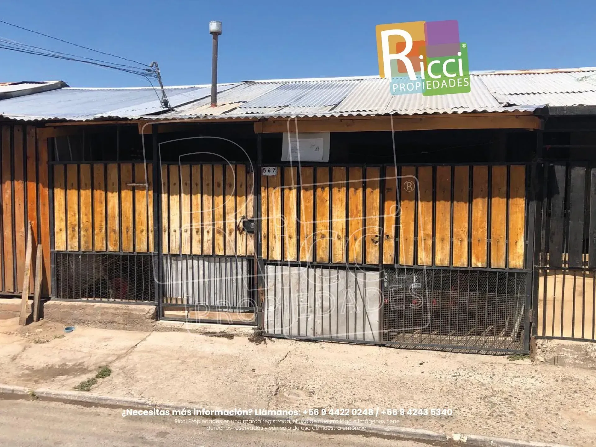 Pequeño local con una reja metálica y fachada de madera bajo un techo de chapa ondulada, con el letrero «Ricci» encima.