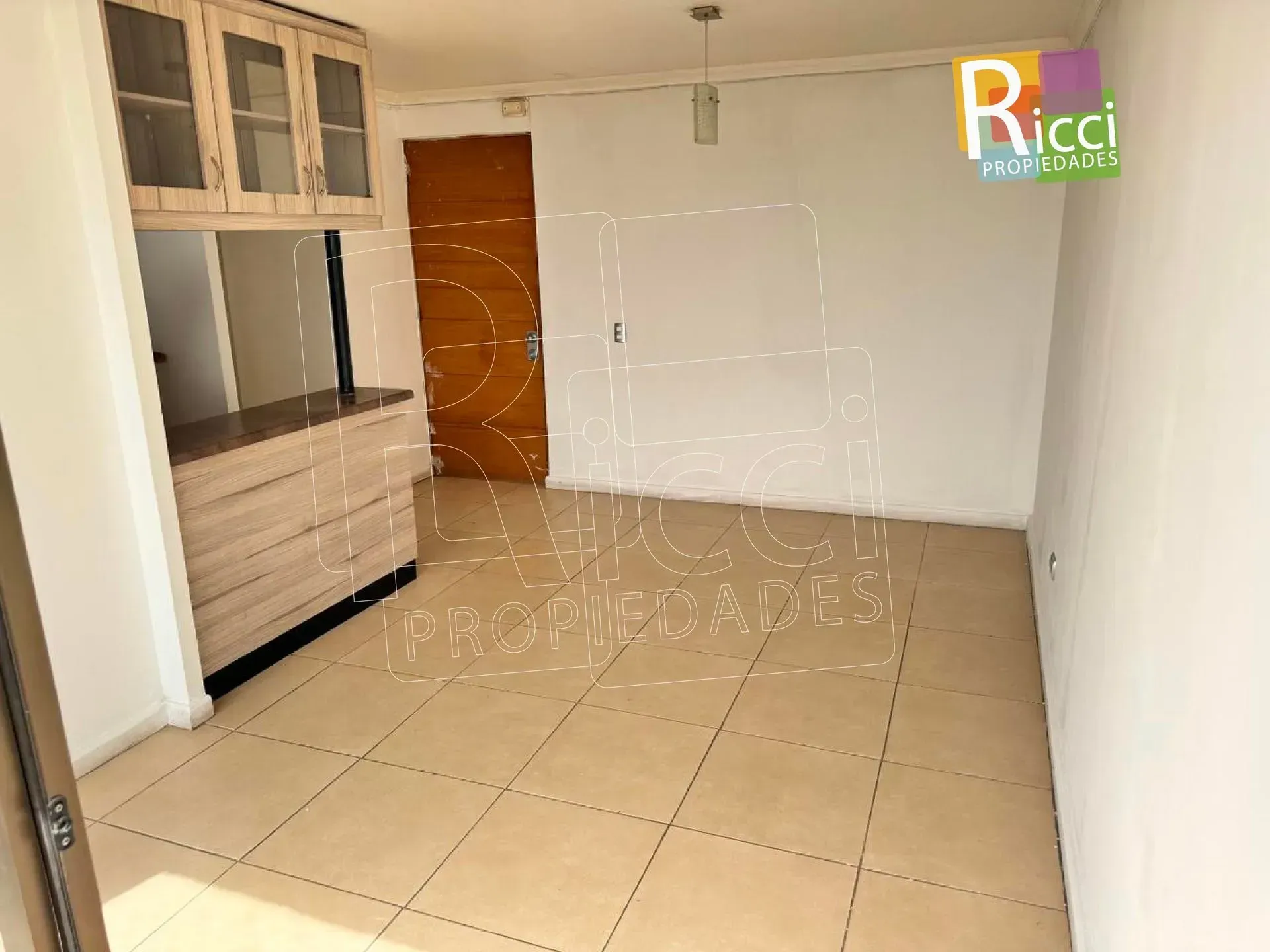 Edificios de apartamentos en una tranquila calle residencial al anochecer, con setos y un logotipo en la esquina superior derecha