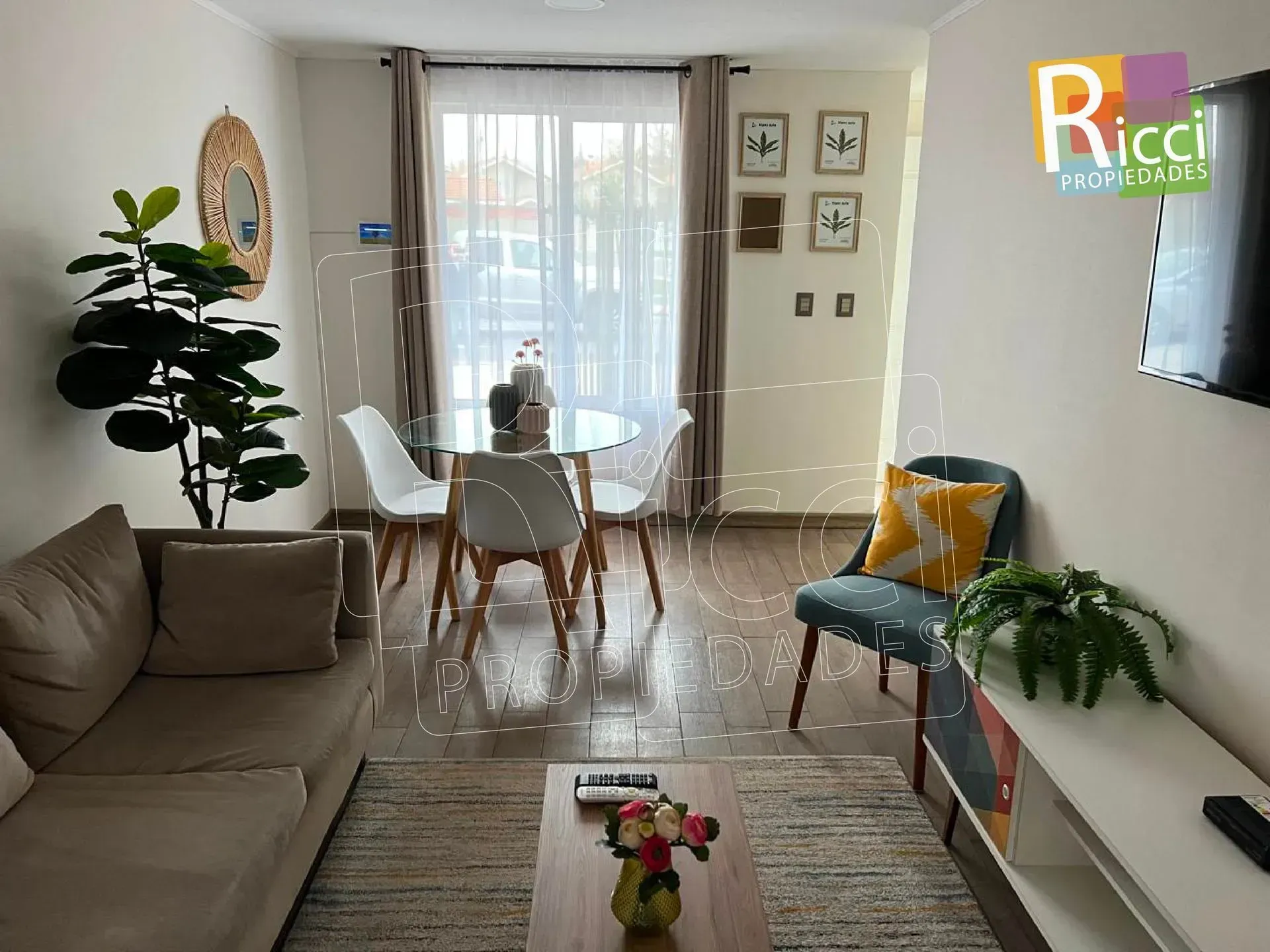 Casa beige de dos plantas con una verja y una cerca metálicas en un barrio residencial