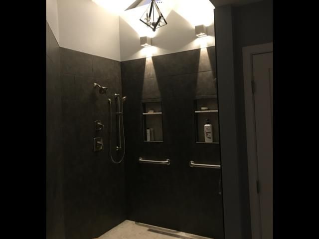 A bathroom with a walk in shower and a ceiling fan.