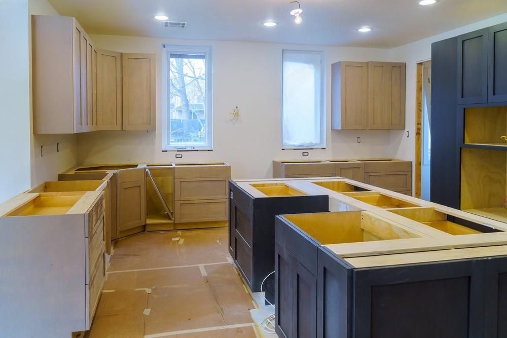 A kitchen under construction with wooden cabinets and a large island.
