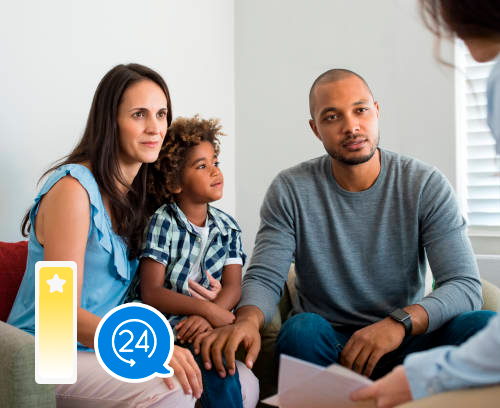 A family is sitting on a couch talking to a doctor.