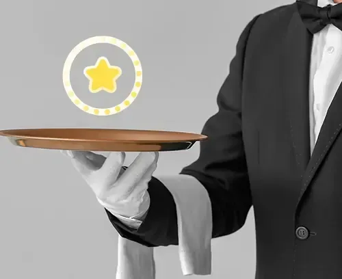 A waiter in a tuxedo is holding a tray with a star on it.