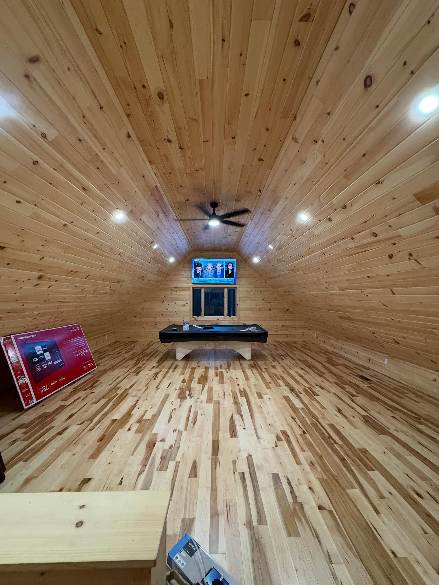 Wooden garage with snowmobiles, people, and doors.