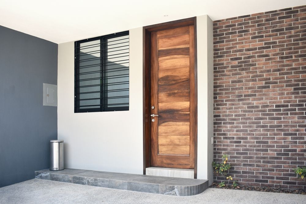 A White House With a Wooden Front Door — Renovo Contractors in Tuggeranong, ACT