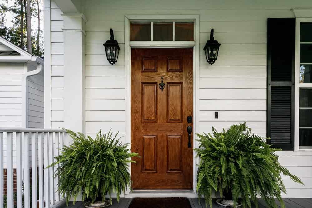 The Front Door Of A House With Ferns In Front Of It — Renovo Contractors In Monash, ACT