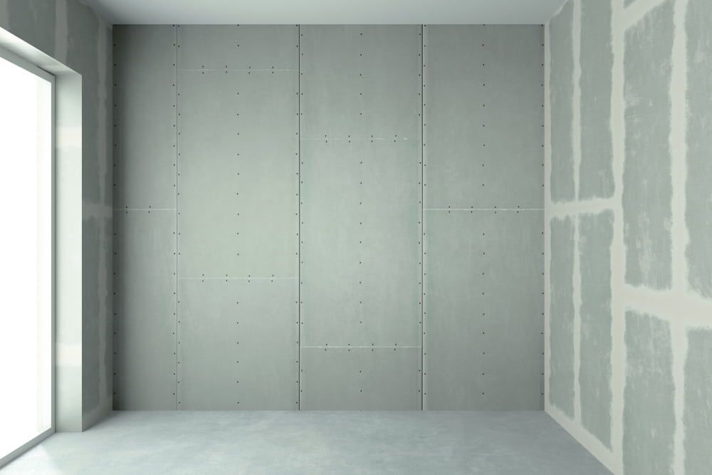 An Empty Room With Concrete Walls And A Large Window — Renovo Contractors In Monash, ACT