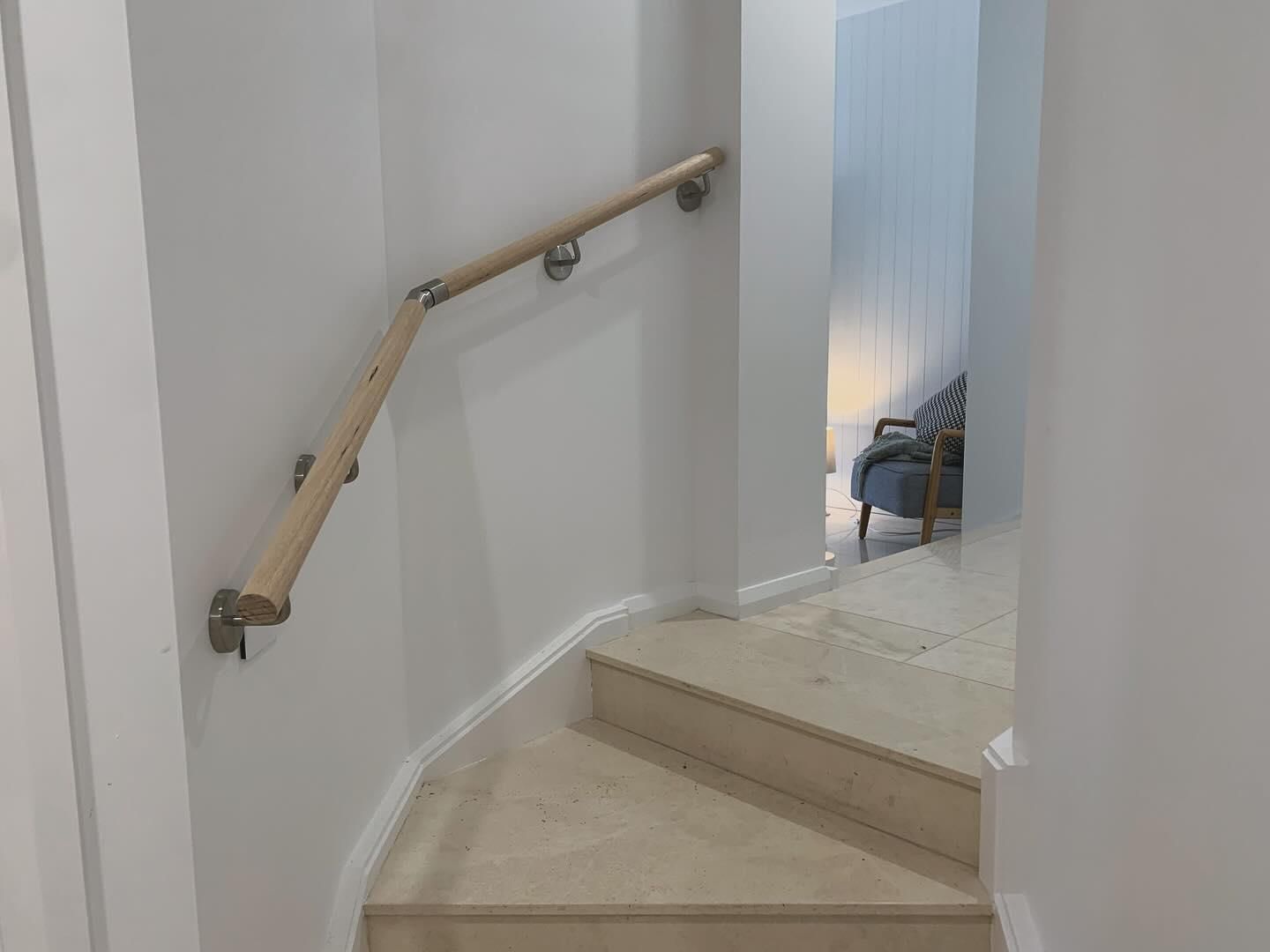 A Staircase With A Wooden Railing And A Chair In The Background — Renovo Contractors In Monash, ACT