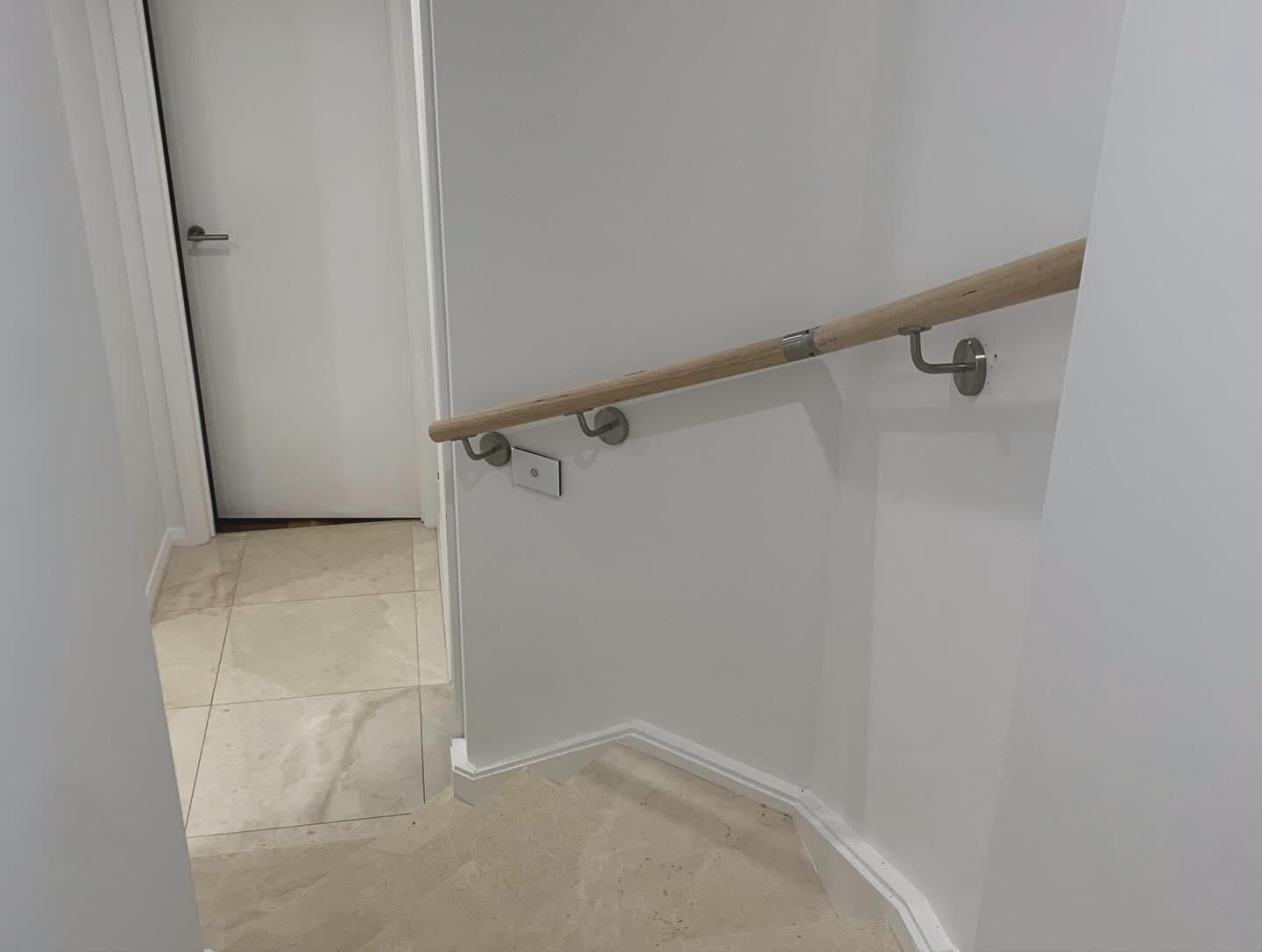 A Staircase With A Wooden Handrail And A Door — Renovo Contractors In Monash, ACT