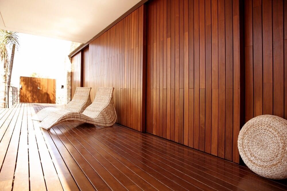 Two Lounge Chairs Are Sitting On A Wooden Deck Next To A Wooden Wall — Renovo Contractors In Monash, ACT