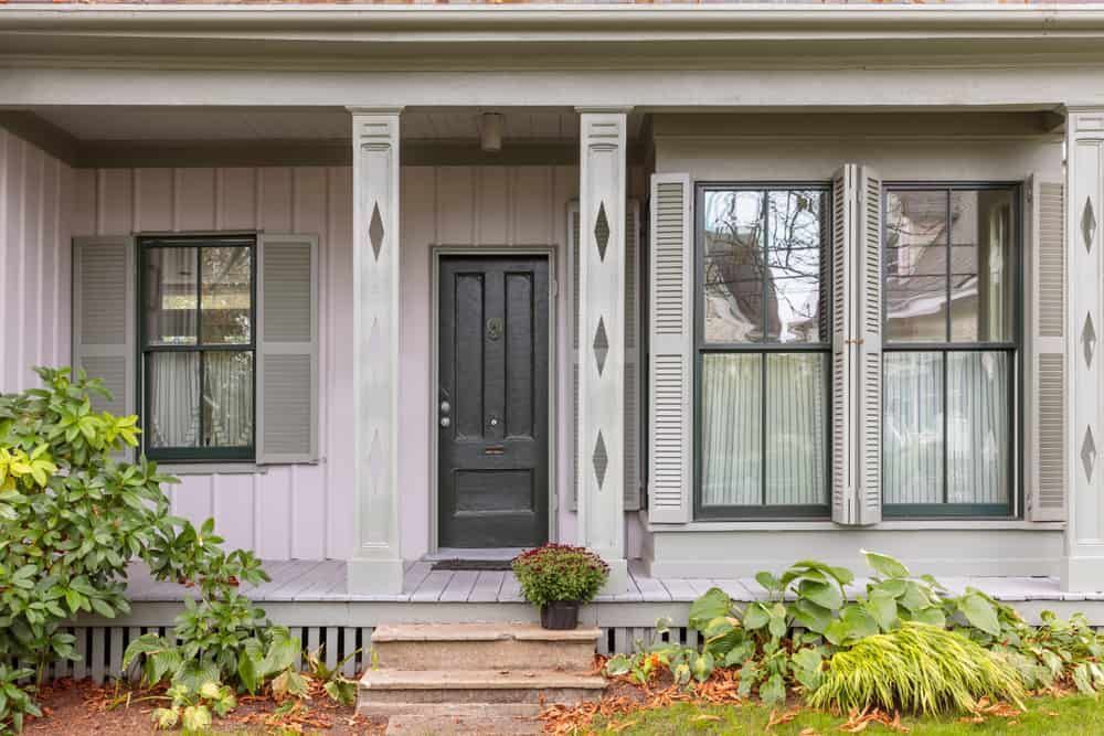 The Front Of A House With A Porch And A Black Door — Renovo Contractors In Monash, ACT