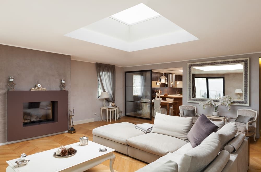 A Living Room With A Couch, Table, Fireplace And Skylight — Renovo Contractors In Monash, ACT