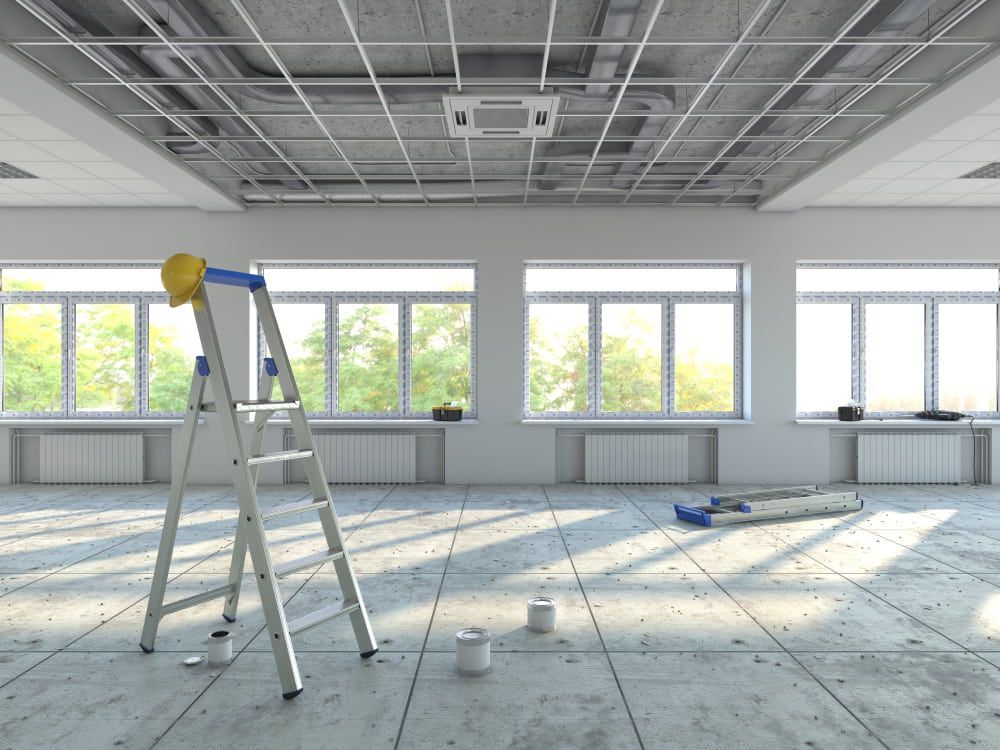 An Empty Room With A Ladder And A Hard Hat On The Floor — Renovo Contractors In Monash, ACT