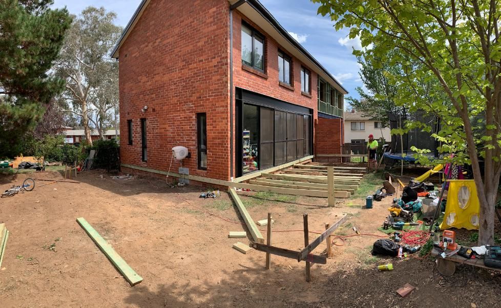 A large brick house is being built in a backyard. — Renovo Contractors In Monash, ACT