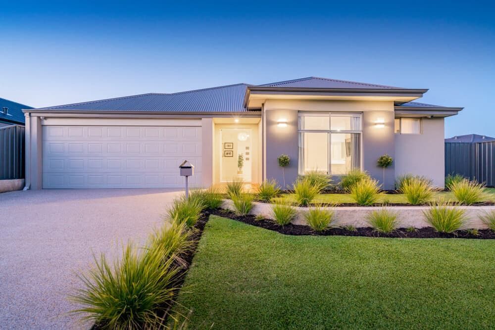A Modern House With A Large Garage And A Lush Green Lawn — Renovo Contractors In Monash, ACT