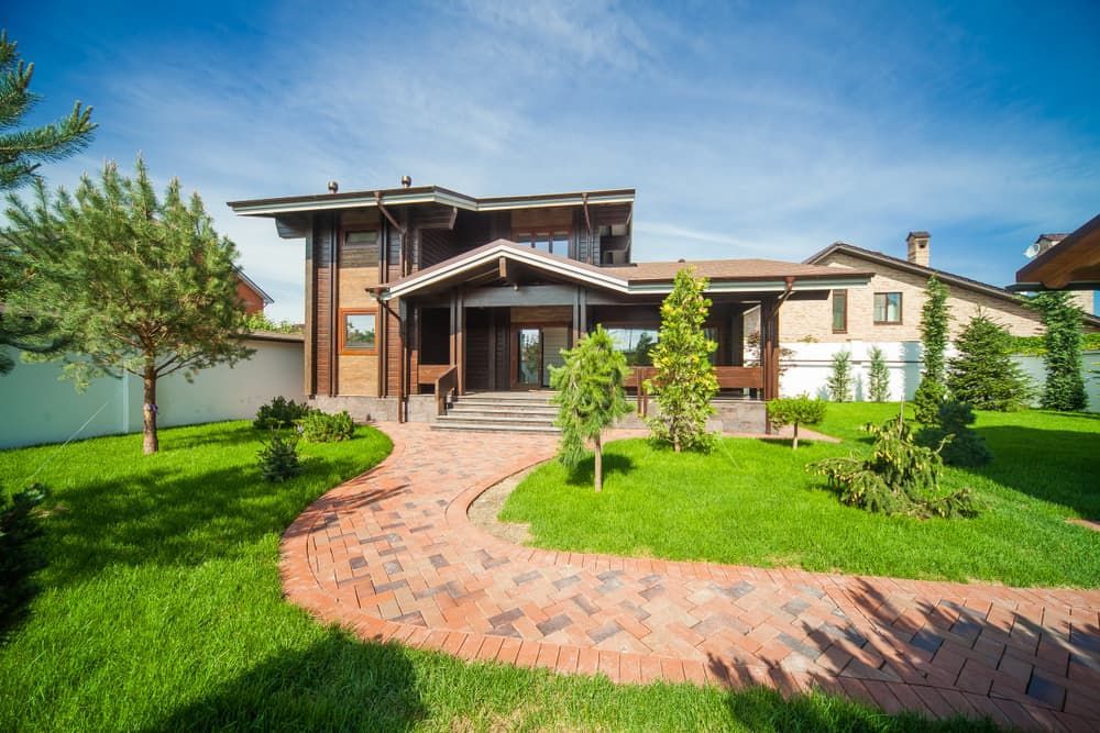A Large House With A Brick Walkway Leading To It And A Lush Green Lawn — Renovo Contractors In Monash, ACT