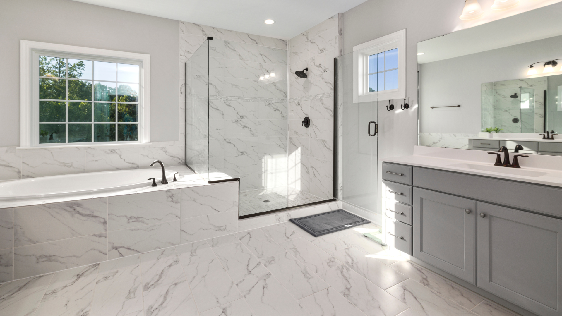 A bathroom with two sinks, a tub, and a walk-in shower.