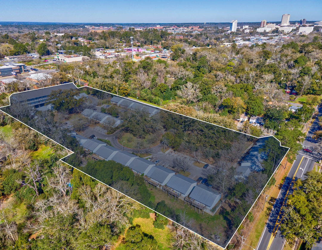 An aerial view of a large residential area with a city in the background.
