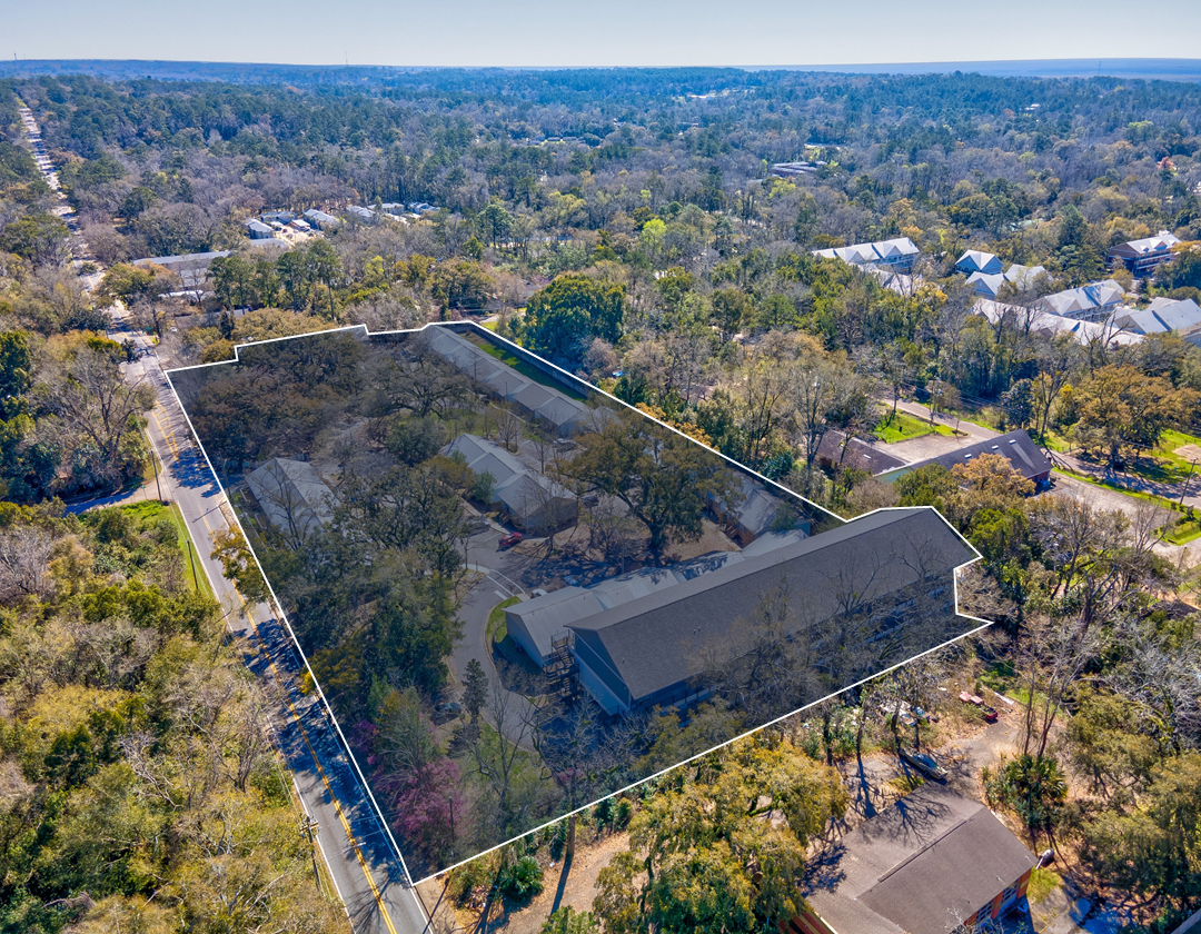 An aerial view of a house in the middle of a forest.
