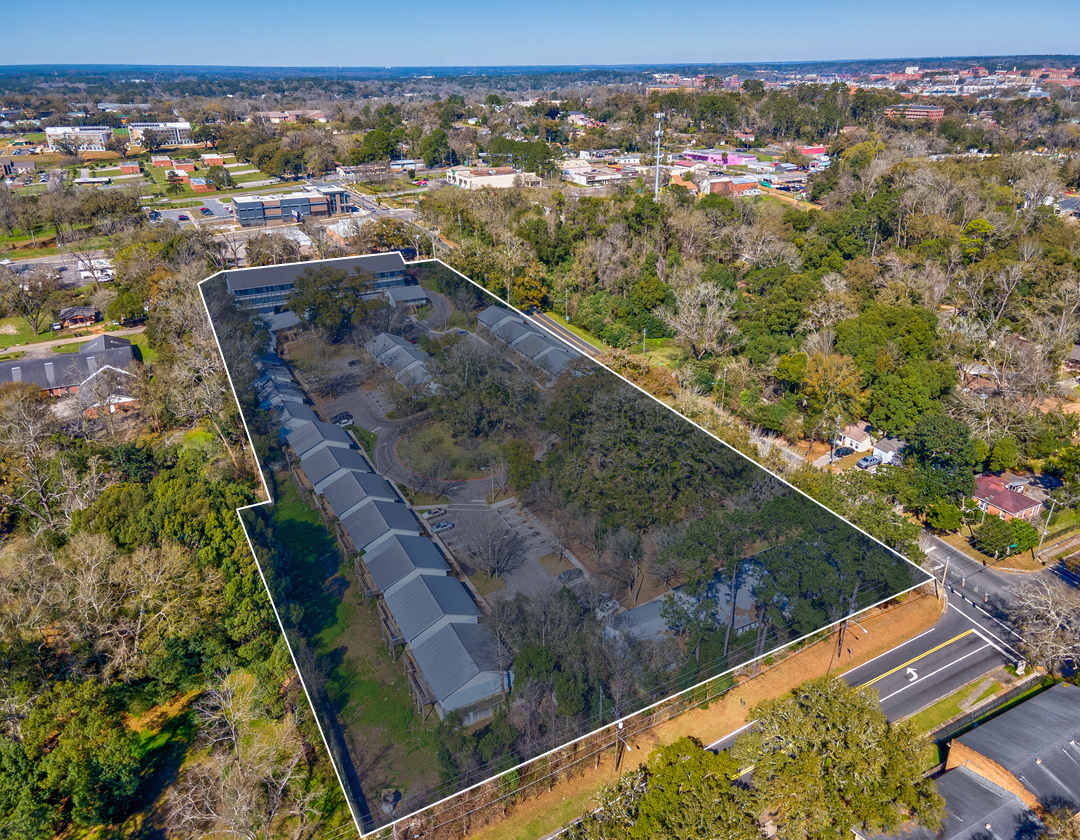 An aerial view of a large residential area surrounded by trees and houses.