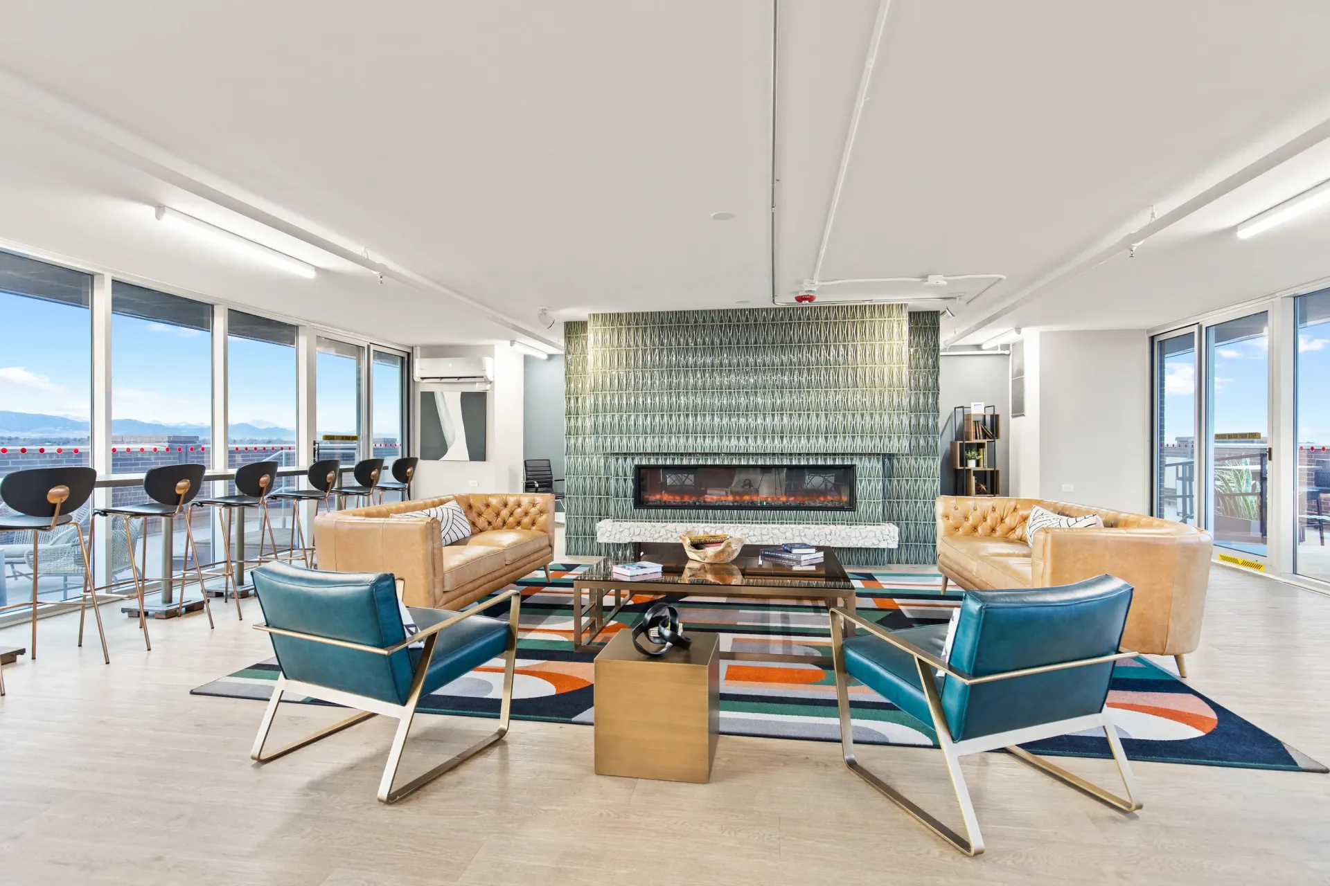 Modern lounge area with a fireplace, seating, and bar seating with a view.