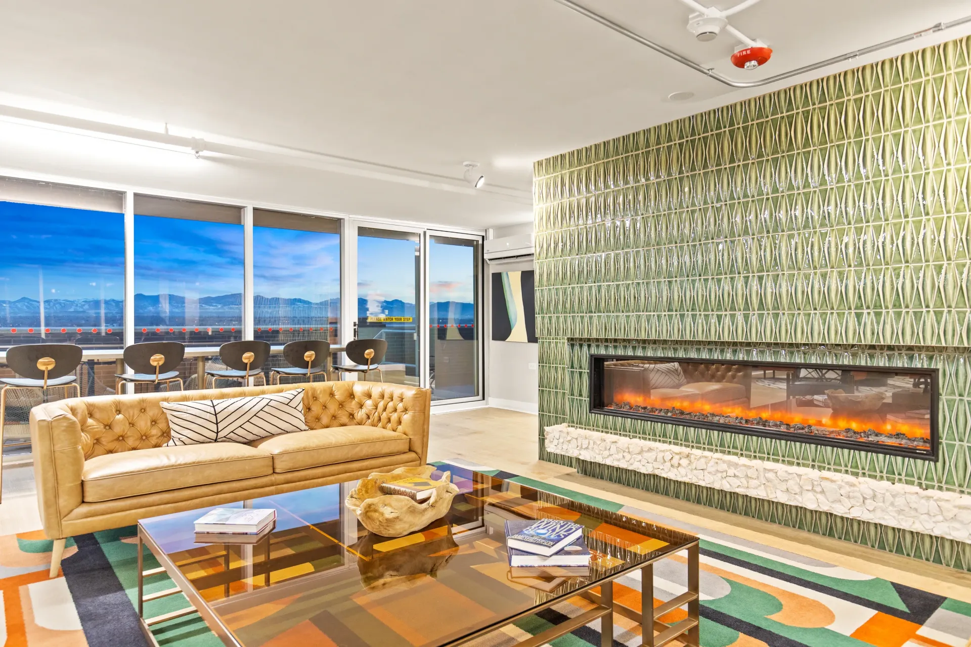 Community lounge with a modern fireplace and large windows offering mountain views.