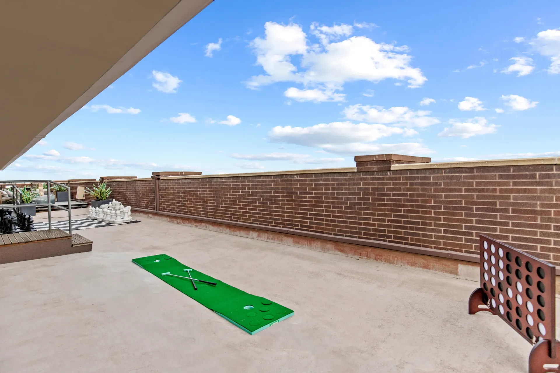 Rooftop patio with giant chess set, putting green, and connect four game.