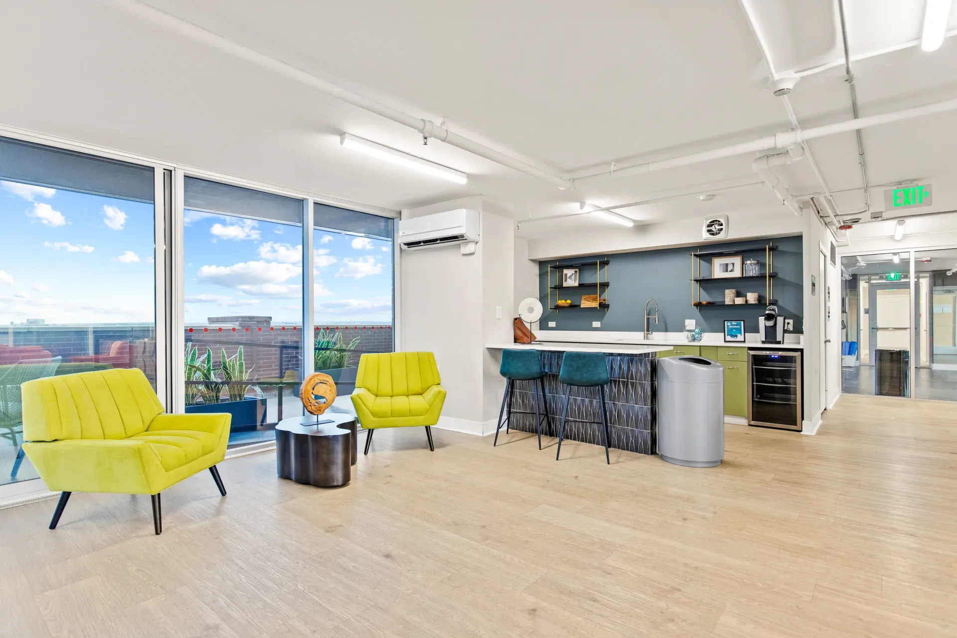 Modern kitchen and lounge area with yellow chairs and large windows
